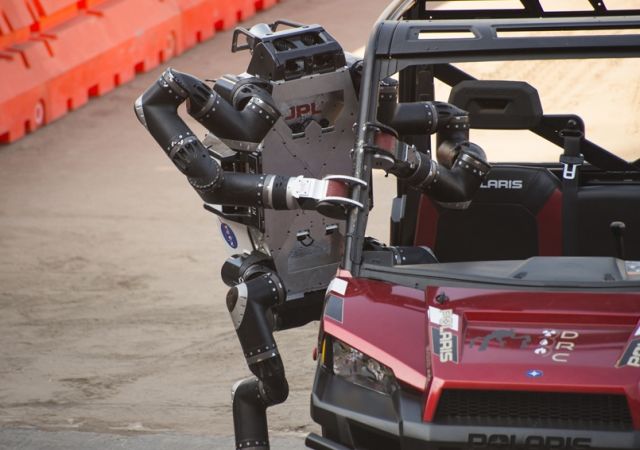 The spindly appearance of JPL's RoboSimian was somewhat unique among competitors in the DARPA challenge, as most were bipedal walkers. Here RoboSimian exits its vehicle following a brief drive through a slalom course at the DARPA Robotics Challenge Finals. project image